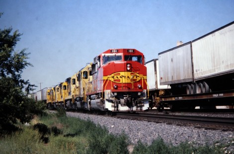 Eastbound Atchison, Topeka and Santa Fe Railway trailers on flatcars (TOFC) train passes counterpart at Mountainair, New Mexico, station in July of 1991. Photograph by J. Parker Lamb. Lamb-03-033-12.JPG; © 2016, Center for Railroad Photography and Art