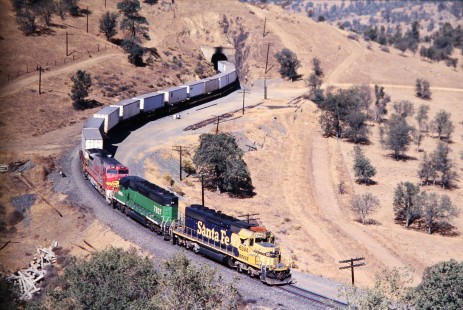 Burlington Northern and Santa Fe Railway locomotives no. 6344, no. 7827, and no. 888 emerge tunnel 19 with eastbound freight. Photograph shot south of Tehachapi Loop in Kern, California, in November of 2002. Photograph by J. Parker Lamb. Lamb-03-046-20.JPG; © 2016, Center for Railroad Photography and Art