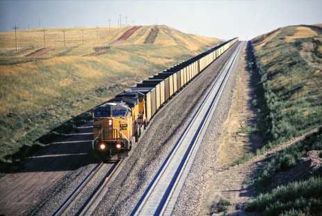 Union Pacific Railroad locomotive no. 6760 with northbound hopper train has topped a grade north of Reno Junction located in Gillette, Wyoming, and now heads downhill in August of 2005. Photograph by J. Parker Lamb. Lamb-03-041-18.JPG; © 2016, Center for Railroad Photography and Art