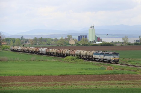 ZSSK Cargo (Cargo Slovakia) double-headed class 752 locomotives on a tank train heading westbound from Plesivec toward Zvolen, in Tornala, Slovakia, on April 27, 2019.