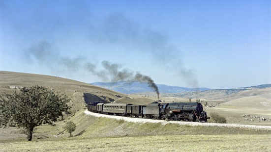 Turkish State Railways steam locomotive 56388 leads a freight train south on the Zonguldak Line near Eskipazar, Turkey, on September 8, 1973. Smoke from pusher locomotive 56332 is visible in the distance. Photograph by Victor Hand, collection of the Center for Railroad Photography & Art, Hand-TCDD-C25-01