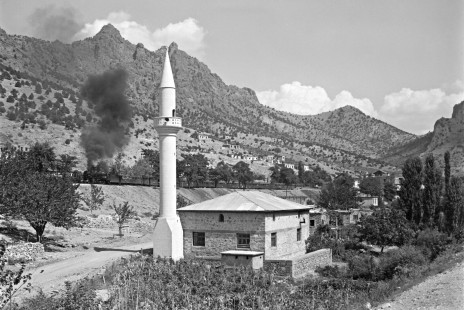 The Turkish State Railways mail train from Kurtalan to Ankara passes a minaret in the village of Çiftehan, Turkey, on September 13, 1973. Photograph by Victor Hand, Collection of the Center for Railroad Photography & Art, Hand-TCDD-25-107