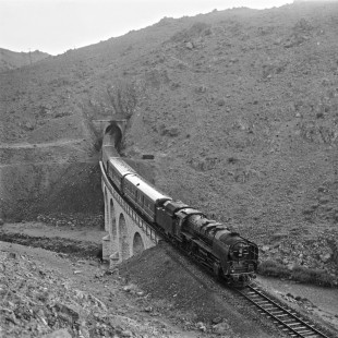 Turkish State Railways 56051, a German-built 2-10-0 steam locomotive, leads a passenger train from Izmir to Kars out of a tunnel and over a viaduct near Cetinkaya, Turkey, on September 11, 1973. Photograph by Victor Hand, collection of the Center for Railroad Photography & Art, Hand-TCDD-25-069