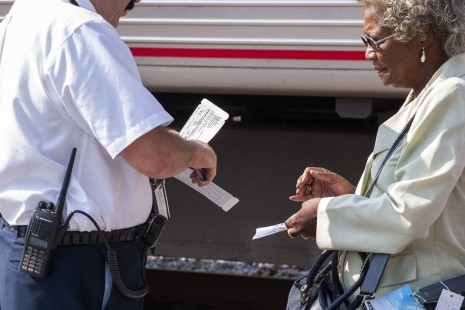 The conductor of Amtrak's <i>Cardinal</i> punches a passenger's ticket as she prepares to board the eastward train at Charleston, West Virginia, on the morning of September 5, 2004. Photograph by Scott Lothes, president and executive director of the Center for Railroad Photography & Art