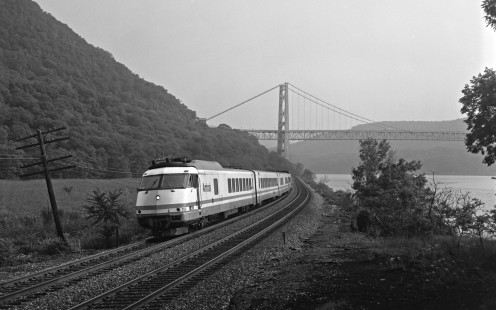 Running as train 265, the <i>Catskill</i>, Amtrak Turboliner 156 cruises up the Hudson River beneath the Bear Mountain Bridge on the evening of August 3, 1994. Built in 1976 by Rohr Industries, the Turboliners ran on the Empire Corridor between New York City and Albany into the early 2000s. Photograph by Victor Hand, collection of the Center for Railroad Photography & Art, Hand-AM-59-627
