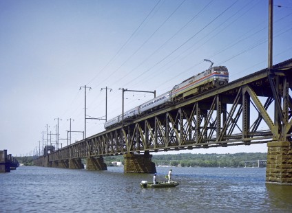 Amtrak <i>Metroliner</i> train 108 from Washington to New York crosses the Susquehanna River at Perryville, Maryland, on May 26, 1980. Two fisherman appear undisturbed by General Electric E60 968 and its three-car train. Photograph by Victor Hand, collection of the Center for Railroad Photography & Art, Hand-AM-C59-055