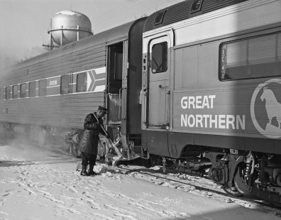 An Amtrak porter sweeps snow from the steps of a passenger car of the <i>North Coast Hiawatha</i> at Fargo, North Dakota, on December 8, 1972. Photograph by Victor Hand, collection of the Center for Railroad Photography & Art, Hand-AM-59-005