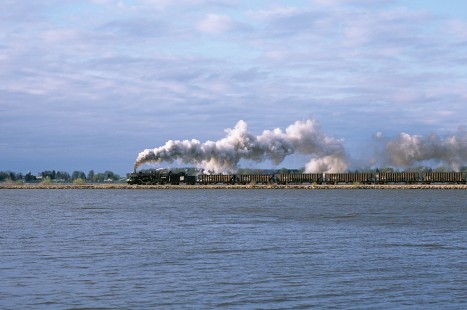 Soo Line Railroad steam locomotive no. 1003 hauls chartered freight train eastbound, operating on Wisconsin and Southern Railroad track over Beaver Dam Causeway at Fox Lake Junction in Wisconsin on April 23, 2005. Photograph by Katherine Botkin. BOTKINK-51-KT-23, © 2005, Katherine Botkin.