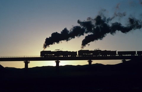 Jitong Railway QJ-class steam locomotive nos. 6998 and 6736 lead westbound train west of Galadesitai Station in Inner Mongolia, China, on November 10, 2001. Photograph by Katherine Botkin. BOTKNIK-103-KT-89 © 2001, Katherine Botkin