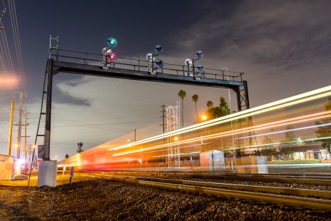 During its final night of operation, the last old-school Santa Fe searchlight signal bridge in the Southwest stands in Riverside, California, as a BNSF intermodal train streaks by on the early morning of November 8, 2020.

Judges' comments: As railroads continue to modernize their network signal systems, this series of three images elegantly depicts a changing of the guard. The judges admired this photographer’s ability to artfully capture the story of transition from veteran searchlight signals to new “Darth Vader” colorlight signals. The first image convincingly captures the “before” while foreshadowing the “new” lurking beyond the signal bridge. The scrapper's torch highlights the second image, with the bridge again in the background. Perhaps most memorable, the third image portrays the fallen soldier with the upgraded system towering above. The judges also noted the photographer’s adept skill with ambient-light night photography in a variety of conditions.

Read more about the 2021 John E. Gruber Creative Awards Program: <a href="https://railphoto-art.org/awards/2021-awards/" rel="noreferrer nofollow">railphoto-art.org/awards/2021-awards/</a>