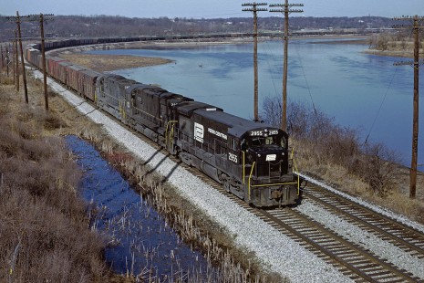 Penn Central U30B 2955 and two ALCOs still in NYC livery head a long eastbound train, possibly NY-4 with the headend stock cars and reefers along the Huron River just east of Ann Arbor, Michigan in April 1969. Photograph by William Botkin, BOTKINW-10-WT-199 © 1969, William Botkin.