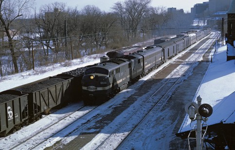 Penn Central No. 17 lead by E-7 4026 and E-8 4066 arrives in Ann Arbor, Michigan in January 1969.  No. 17 ran from Detroit to Chicago and carried a lounge car, coaches and sleepers.  This day the mid-train baggage cars indicated that it was also carrying some deadhead coaches.  In the lower right corner of the photo is the train order signal. Photograph by William Botkin, BOTKINW-10-WT-183 © 1969, William Botkin.