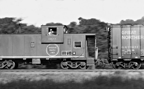 Conductor of northbound Missouri Pacific Railroad freight train waves to photographer at Snead siding in north Austin, Texas, in August 1976. Photograph by J. Parker Lamb, © 2016, Center for Railroad Photography and Art. Lamb-02-063-01