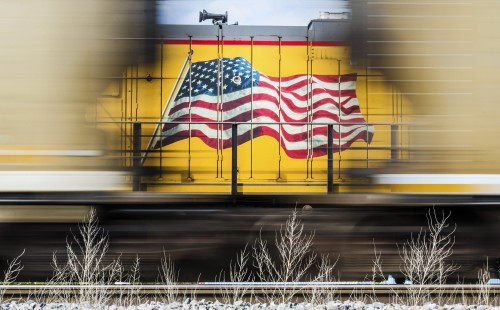 “Red, White and Blur.” The flag on a Union Pacific locomotive and a loaded coal train speeding by near Seward, Nebraska, on September 17, 2015. Read more at <a href="http://www.railphoto-art.org/2015-awards" rel="nofollow">www.railphoto-art.org/2015-awards</a>