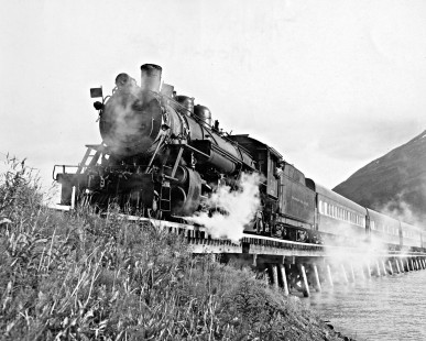 Alaska Railroad Baldwin 2-8-2 steam locomotive no. 701 leads passenger train through Moose Pass on July 11, 1948. Photograph by Alaska Railroad, and from the Leo King Collection, Center for Railroad Photography and Art. King-06-110-001