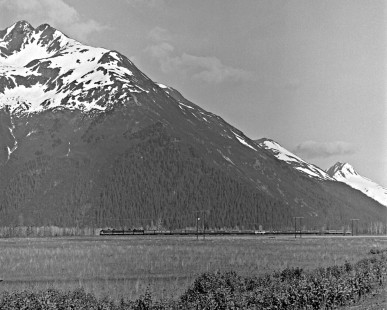 Alaska Railroad northbound passenger train in front of mountains on the Kenia Peninsula, c. 1973. Photograph by Leo King, © 2015, Center for Railroad Photography and Art. King-03-042-007