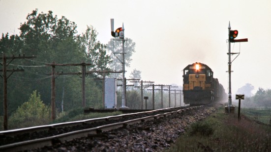 Eastbound Chicago and North Western Railway freight train passing semaphore signals in Necedah, Wisconsin, on May 29, 1976. Photograph by John F. Bjorklund, © 2015, Center for Railroad Photography and Art.  Bjorklund-24-21-09