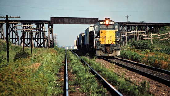 Eastbound Chicago and North Western Railway freight train in Boone, Iowa, on July 6, 1981. The bridge in the background is the CNW's former Ft. Dodge, Des Moines & Southern interurban line. Photograph by John F. Bjorklund, © 2015, Center for Railroad Photography and Art. Bjorklund-27-06-06