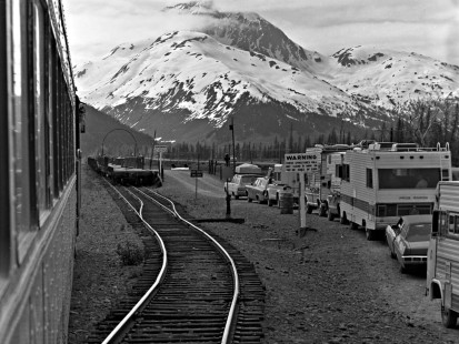 View of Alaska Railroad tracks and vehicles waiting to board the Whittier Shuttle train, c. 1973. Photograph by Leo King, © 2015, Center for Railroad Photography and Art. King-03-027-008
