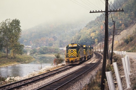 Eastbound Delaware and Hudson Railway freight train running along the Canisteo River between Cameron Mills and Rathbone, New York, on October 3, 1976. Photograph by John F. Bjorklund, © 2015, Center for Railroad Photography and Art. Bjorklund-18-21-21