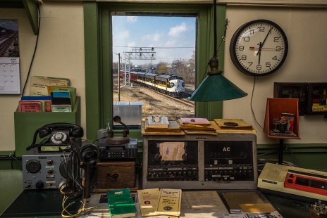 A clever combination of the interior of the preserved interlocking tower at Marion, OH., complete with everything from telegraph sounder to railroad radio, and a passing NS office car special.