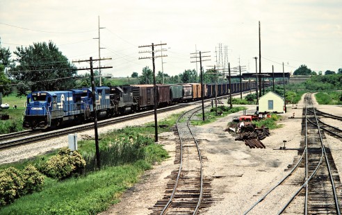 Westbound Conrail freight train in Delta, Ohio, on June 6, 1982. The train is passing under the Detroit, Toledo and Ironton Railroad in the background; connecting tracks are at right. Photograph by John F. Bjorklund, © 2015, Center for Railroad Photography and Art. Bjorklund-29-04-09