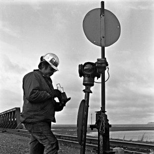 Alaska Railroad worker putting a lantern inside a switch stand, c. 1973. Photograph by Leo King, © 2015, Center for Railroad Photography and Art. King-03-063-009