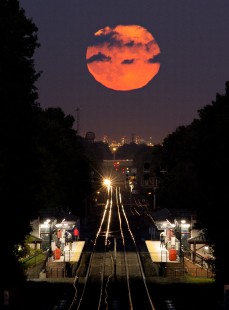 Photographer's notes: On the evening of October 8, 2014, a full moon rises over NJ Transit's ex-Jersey Central Raritan Valley Line in Westfield, New Jersey. The headlights of a westbound train leaving Cranford station, nearly three miles distant, set the rails aglow.

Read more about the <a href="http://www.railphoto-art.org/awards/2016-awards/" rel="nofollow">2016 John E. Gruber Creative Photography Awards Program</a>.
