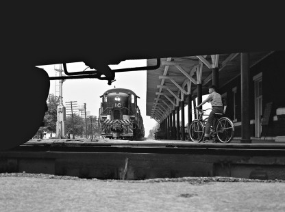 At Selma, North Carolina, in June 1962, a boy on a bicycle watches as a Southern Railway local freight train waits for the passage of Atlantic Coast Line train no. 376, the <i>Everglades</i>. Photograph by J. Parker Lamb, © 2016, Center for Railroad Photography and Art. Lamb-01-083-04