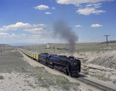 Union Pacific Railroad steam locomotive no. 8444 leads eastbound excursion train between Lararmie, Wyoming, and Denver, Colorado, on May 30, 1969. Image was shot at Warren, Colorado. Photograph by Victor Hand. Hand-UP-C64-30.JPG;