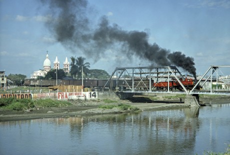 Guayaquil-Quito Railway steam locomotive no. 7 with a freight train and a rider coach crosses a bridge in Yaguachi, Guayas, Ecuador, on July 8, 1990. Photograph by Fred M. Springer, © 2014, Center for Railroad Photography and Art, Springer-ECU1-22-21
