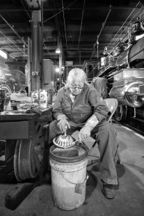 An worker at the Golden Spike National Historic Site meticulously cleans the locomotive parts in preparation for the May 10th anniversary date. Photograph by Eric Baumgartner.