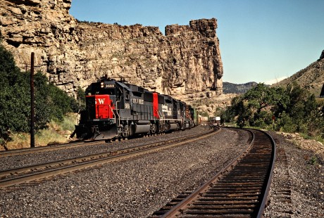 Westbound Southern Pacific freight train beginning the climb up the Denver and Rio Grande Western's Soldier Summit at Castle Gate, Utah, on July 7, 1993. The Rio Grande acquired the much larger Southern Pacific in 1988, but retained the name of the bigger road. Photograph by John F. Bjorklund, © 2015, Center for Railroad Photography and Art. Bjorklund-49-13-07
