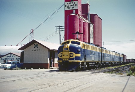 A four-unit set of Santa Fe Railway FT locomotives taking a freight train past a grain elevator in Happy, Texas, in September 1960. Photograph by Fred M. Springer, © 2016, Center for Railroad Photography and Art. Springer-TX1-24-22