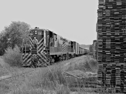 Inbound Meridian and Bigbee Railroad freight train passes large stacks of sawed lumber en route to downtown in July 1958. Photograph by J. Parker Lamb, © 2016, Center for Railroad Photography and Art. Lamb-02-033-10