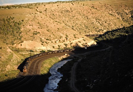 Westbound coal train climbing the Denver and Rio Grande Western's grade to Soldier Summit along the Price River near Kyune, Utah, on July 7, 1993. This is technically a Southern Pacific train—the Rio Grande acquired the much larger SP in 1988, but retained the name of the bigger road. Photograph by John F. Bjorklund, © 2015, Center for Railroad Photography and Art. Bjorklund-49-14-13