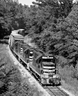 Westbound Meridian and Bigbee Railroad freight train plows through thick forests east of Meridian, Mississippi, behind road's first chopped-nose Geep in August 1983. Photograph by J. Parker Lamb, © 2016, Center for Railroad Photography and Art. Lamb-02-034-03
