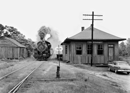 Northbound Bonhomie and Hattiesburg Southern Railroad freight train passes station at New Augusta, Mississippi, in August 1958. (The photographer noted that parking his car in the shot was "a mistake in haste," but we're glad it's there.) Photograph by J. Parker Lamb, © 2016, Center for Railroad Photography and Art. Lamb-02-033-02