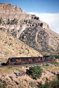 Westbound coal train at Helper, Utah, beginning the climb up the Denver and Rio Grande Western's grade to Soldier Summit on July 7, 1993. This is technically a Southern Pacific train—the Rio Grande acquired the much larger SP in 1988, but retained the name of the bigger road. Photograph by John F. Bjorklund, © 2015, Center for Railroad Photography and Art. Bjorklund-49-14-22