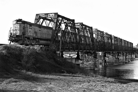Eastbound Chicago & North Western loaded iron ore train crossing the Escanaba RIver Bridge at Escanaba, Michigan, in May 1984. Tracks of the Escabana & Lake Superior, which cross under the C&NW bridge, are visible in the foreground at right. Leading the train are three of the C&NW's big Alco C628 locomotives, which last operated just two years later in 1986.