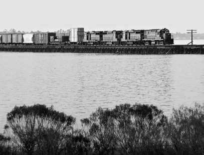 Freight train from New Orleans, Louisiana, to Jacksonville, Florida, led by Seaboard Coast Line Railroad power, eases across Louisville and Nashville Railroad's Biloxi Bay bridge in August 1960. Photograph by J. Parker Lamb, © 2016, Center for Railroad Photography and Art. Lamb-01-138-03