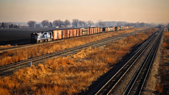 Southbound Conrail freight train near Vienna, Michigan, on March 22, 1987. The tracks in the foreground belong to the Grand Trunk Western, which also has a southbound freight train approaching in the distance. The middle track is another Conrail line. Photograph by John F. Bjorklund, © 2015, Center for Railroad Photography and Art. Bjorklund-30-12-16