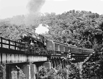 Louisville and Nashville Railroad Pacific steam locomotive no. 230 leads local passenger train no. 86 across a bridge west of Attalla, Alabama, in August 1951. The train followed a U-shaped route between Birmingham and Calera, during which it switches numbers four times. Photograph by J. Parker Lamb, © 2016, Center for Railroad Photography and Art. Lamb-01-136-05