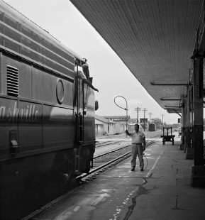 The operator at Biloxi, Mississippi, hands up orders to northbound Louisville and Nashville Railroad local train in June 1955. Photograph by J. Parker Lamb, © 2016, Center for Railroad Photography and Art. Lamb-01-137-01