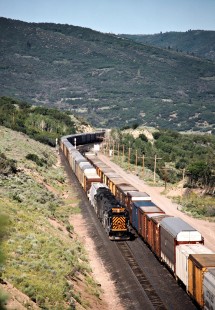 Eastbound and westbound freight trains passing at Gilluly, Utah, on July 7 1993. This is the Denver and Rio Grande Western Railroad's line over Soldier Summit, technically the Southern Pacific since 1988, when the Rio Grande acquired the SP and retained its name. Photograph by John F. Bjorklund, © 2015, Center for Railroad Photography and Art. Bjorklund-49-12-09