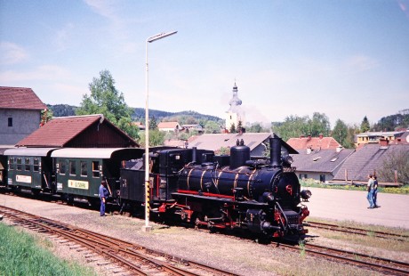 A worker couples Waldviertler Narrow-Gauge Railway Club 0-8-4T steam locomotive no. 399.04 to its train as a young couple observes at the station in Gerungs, Lower Austria, Austria, on May 13, 2001. Photograph by Fred M. Springer, © 2014, Center for Railroad Photography and Art. Springer-Austria-05-14