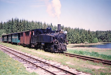 Jindřichův Hradec narrow gauge railway steam locomotive no. U47-001 journeys beside a small forest and lake in Hurky, Lower Austria, Austria, on May 14, 2001. Photograph by Fred M. Springer, © 2014, Center for Railroad Photography and Art. Springer-Austria-07-19