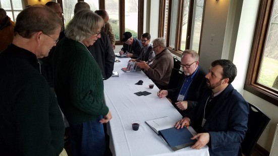 Attendees Dave Saums and Ted Benson visit authors Scott Lothes, Kevin Keefe, John Gruber, John Ryan, and unidentified at book signing table at Saturday evening reception. Center for Railroad Photography & Art. Photograph by Otto Vondrak.