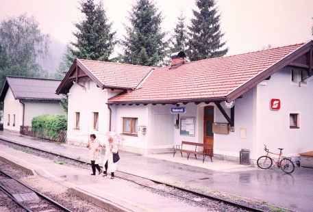 Two women carry umbrellas across the train platform at Niedernsill Station in Niedernsill, Salzburg, Austria, on May 18, 2001. Photograph by Fred M. Springer, © 2014, Center for Railroad Photography and Art. Springer-Austria-13-04
