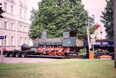 Steam locomotive no. 106 is transported on a flatbed trailer driven by a truck in Linz, Upper Austria, Austria, on May 22, 2001. Photograph by Fred M. Springer, © 2014, Center for Railroad Photography and Art. Springer-Austria-18-17